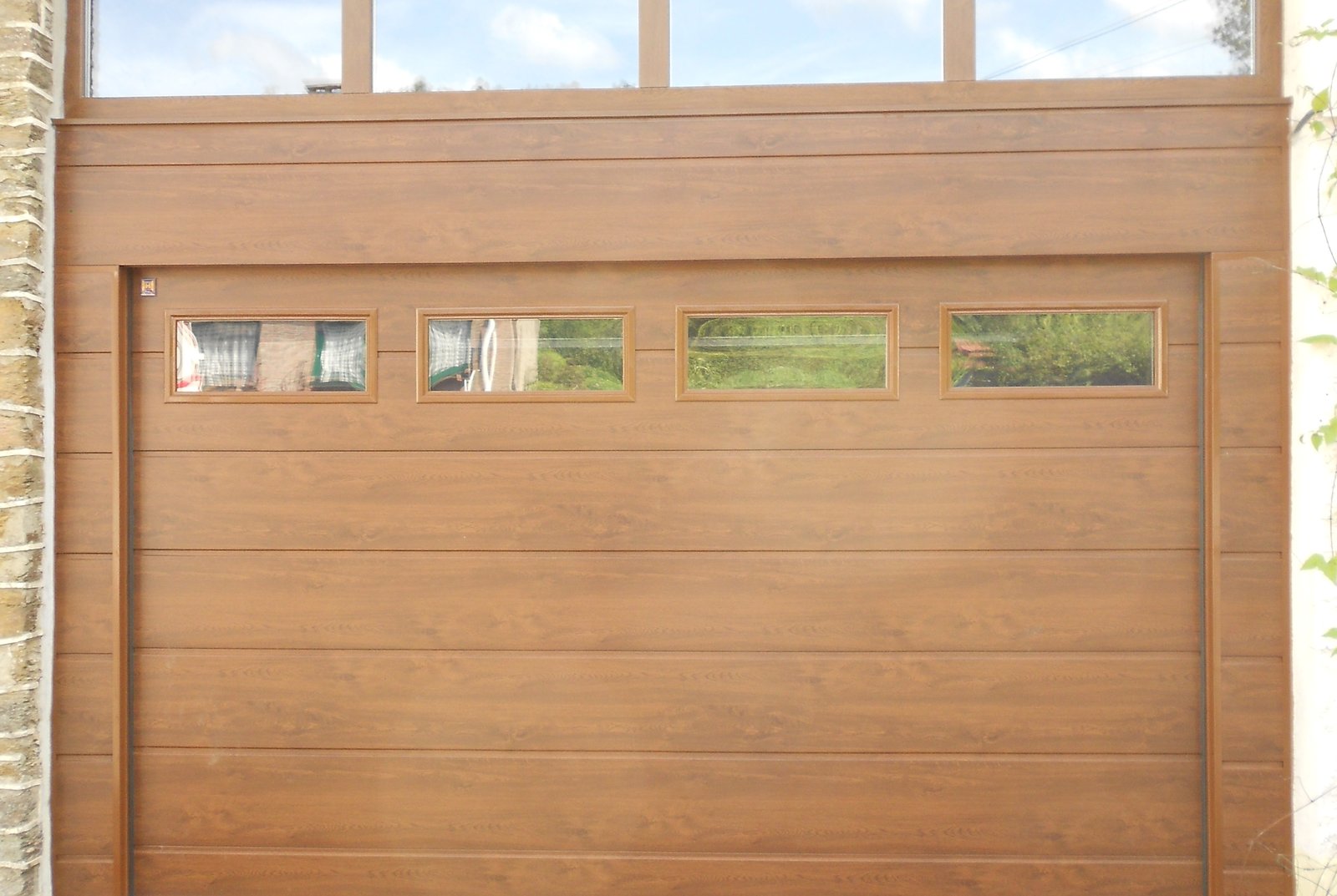 Porte de garage sectionnelle en bois avec hublots